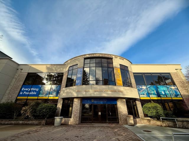 Exterior of the Hofstra University School of Law building with large windows and banners displaying 'Everything is Possible'.